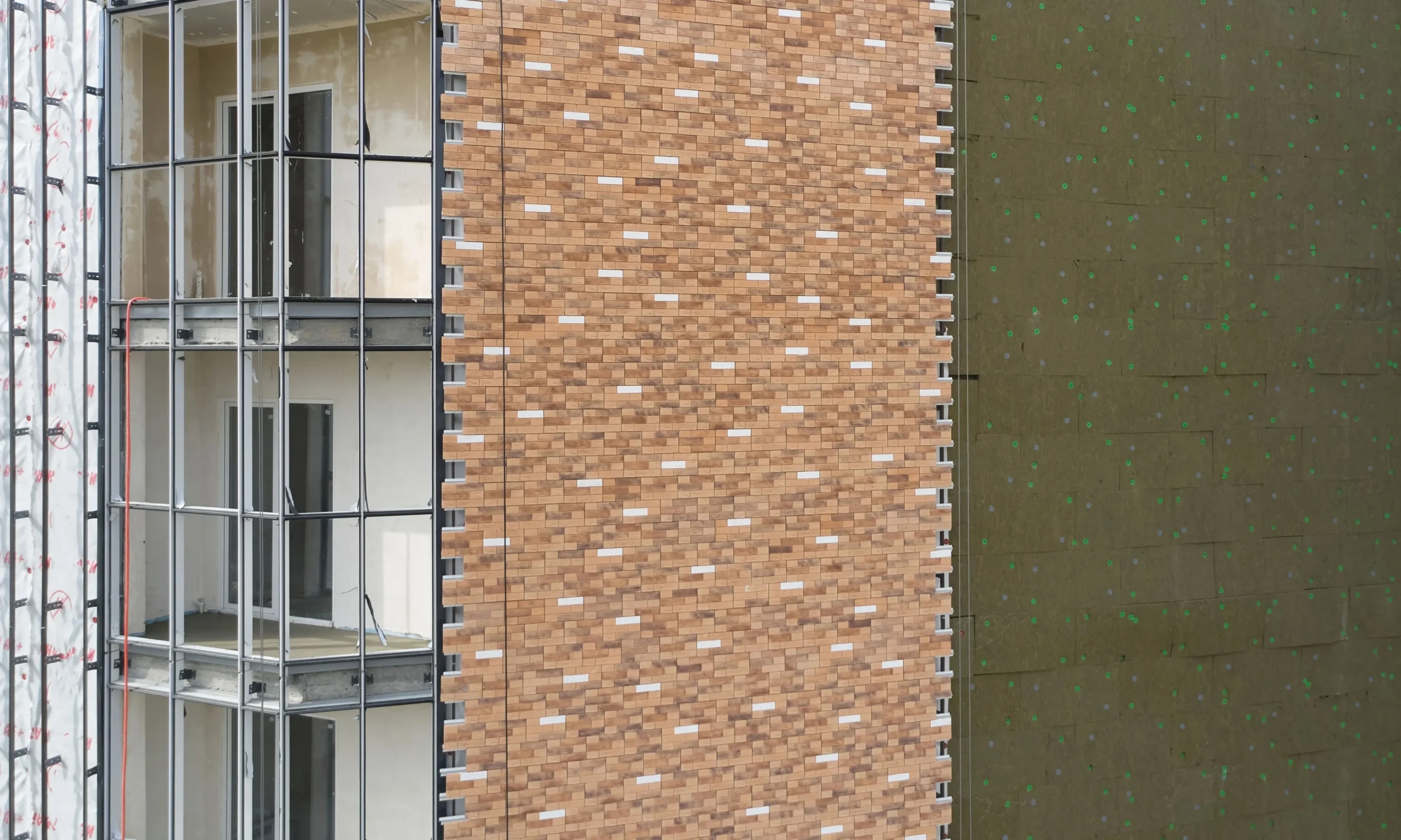 Professional K Rend external wall insulation installation showing insulation boards fixed to building wall with mechanical fixings and adhesive, demonstrating proper EWI system application techniques