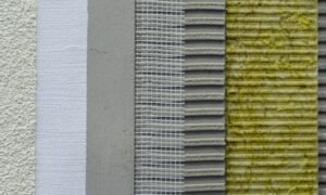 Cross-section of wall insulation layers: plaster, adhesive, reinforcing mesh, adhesive layer, and mineral wool.